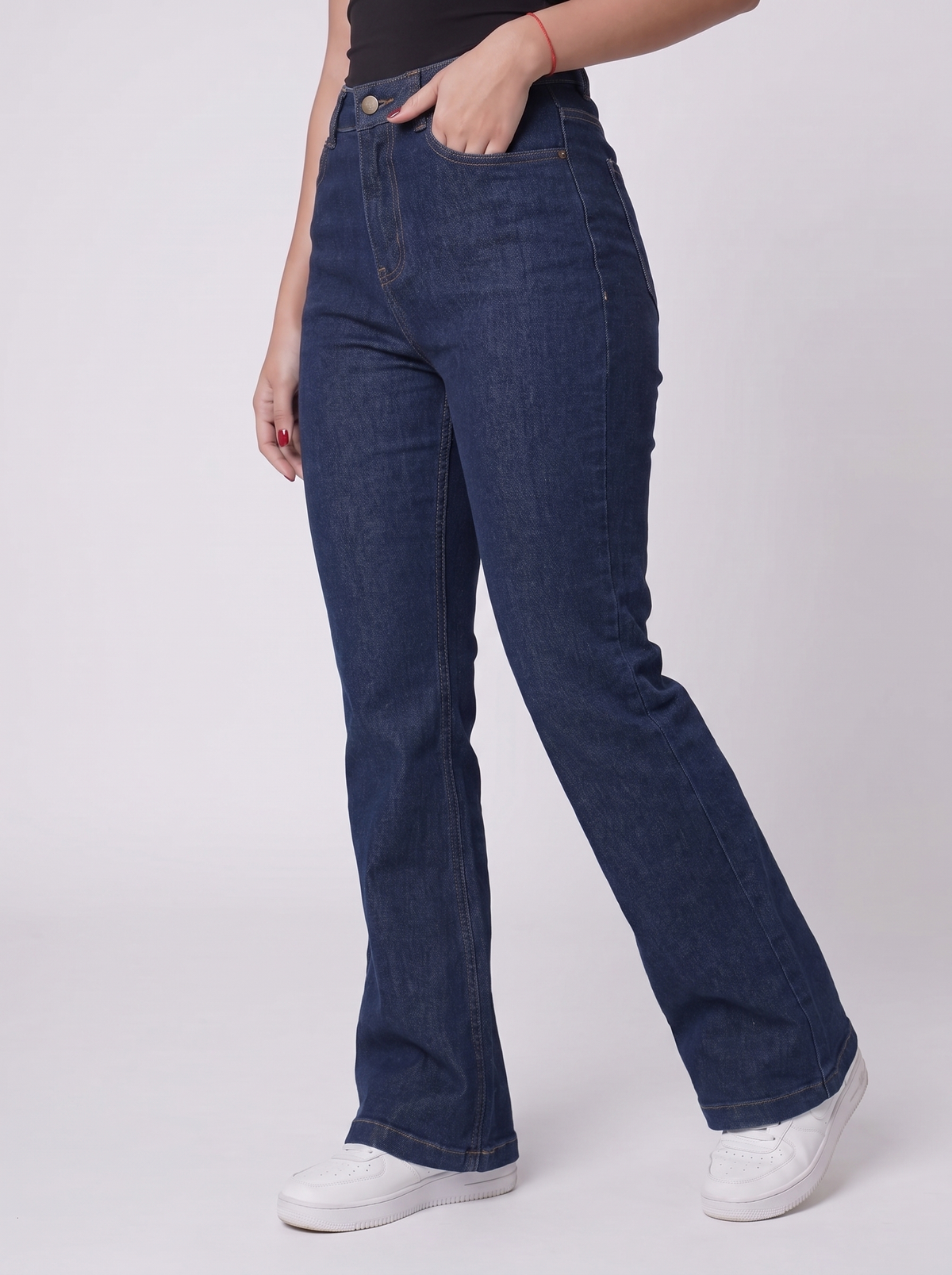 The Raw Indigo Flare — editorial full body, warm studio backdrop