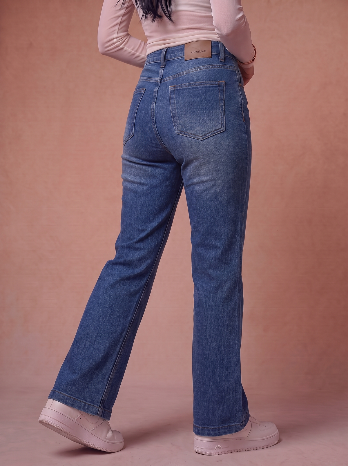 The Patch Flare — back view, waist to feet, vintage indigo wash