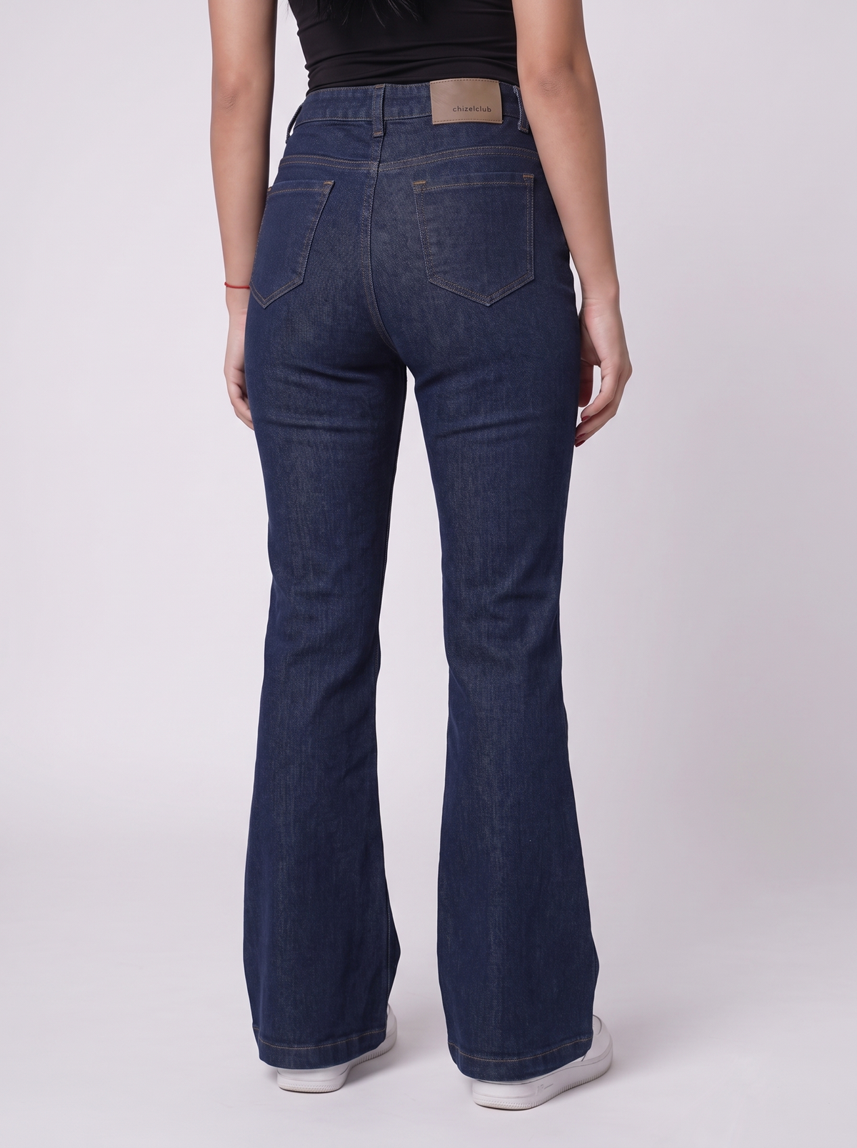 The Raw Indigo Flare — back view, waist to feet, deep raw unwashed indigo